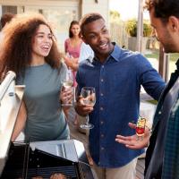 Trois amis déguste un vin autour d'un barbecue