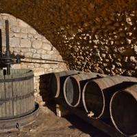 Vielle presse à vin et vielles barriques en cave