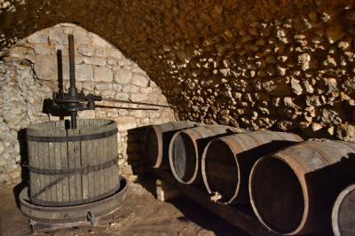 Vielle presse à vin et vielles barriques en cave